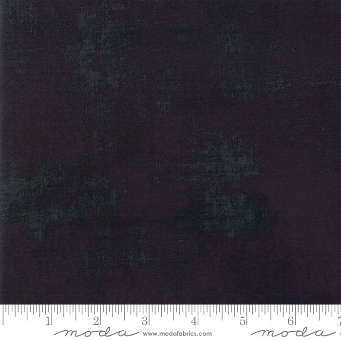 a swatch of quilting fabric showing a black grunge fabric with a ruler at the bottom to show scale