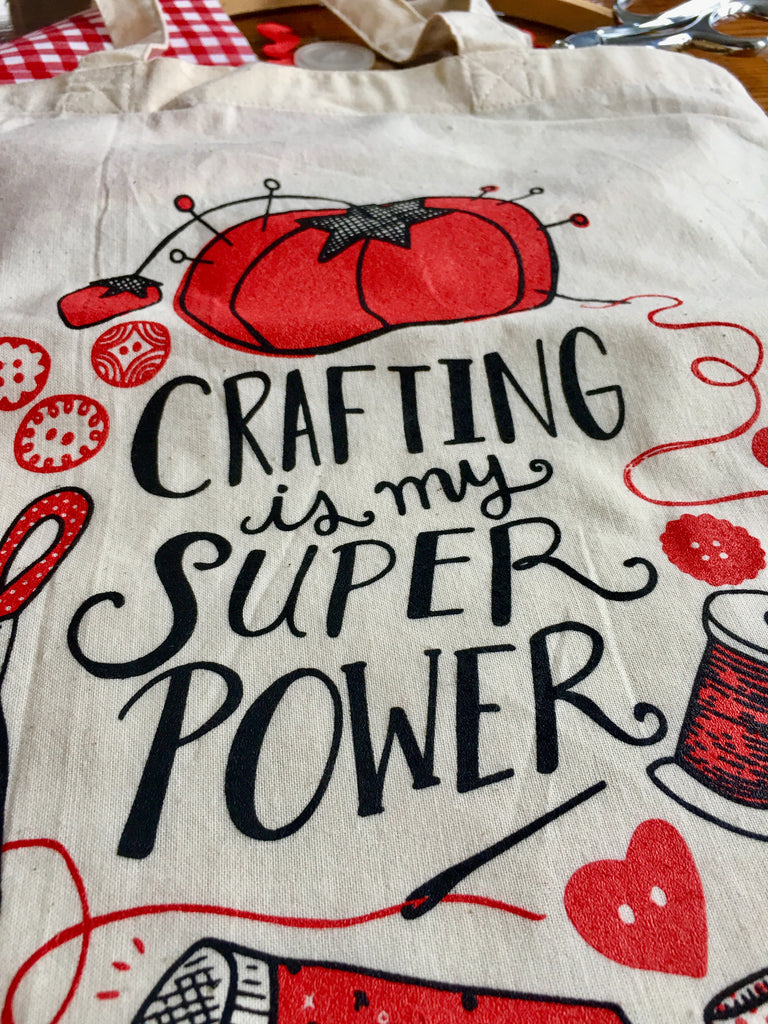 Close up of canvas tote bag printed with a design reading "crafting is my super power"
