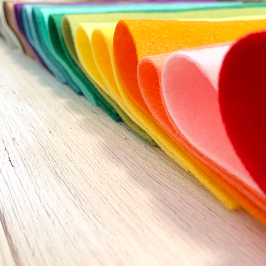 Sheets of rainbow colored felt folded in half in a row