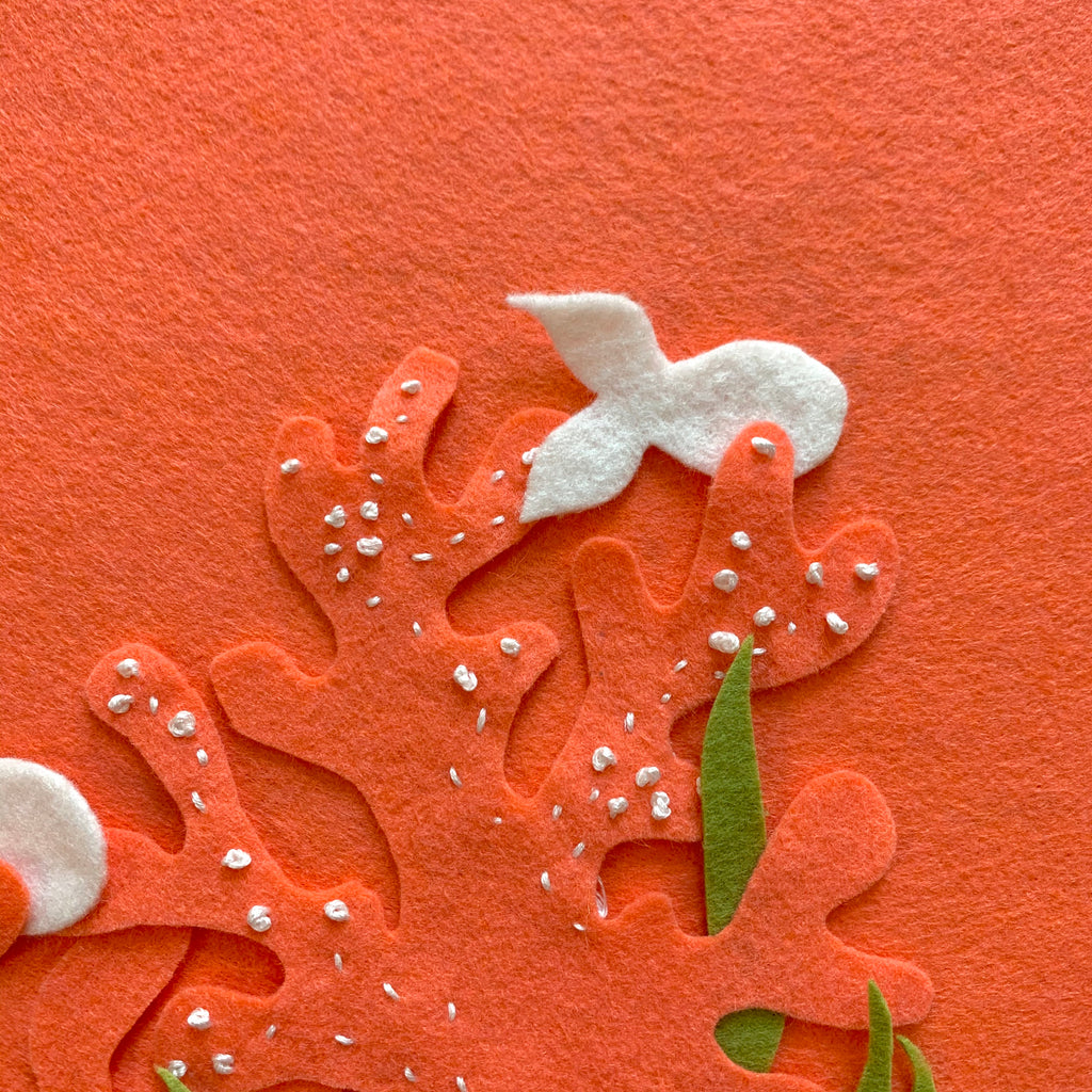 close up of coral felt, small white fish cut out of felt