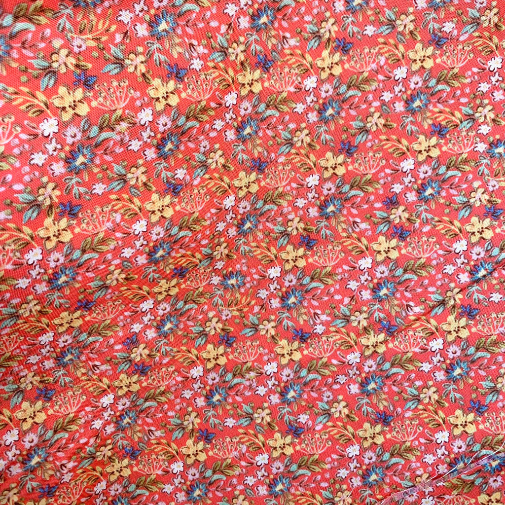 a close up of quilting cotton fabric with red ditsy florals